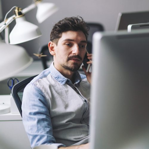 handsome-businessman-working-in-office-using-mobile-phone.jpg